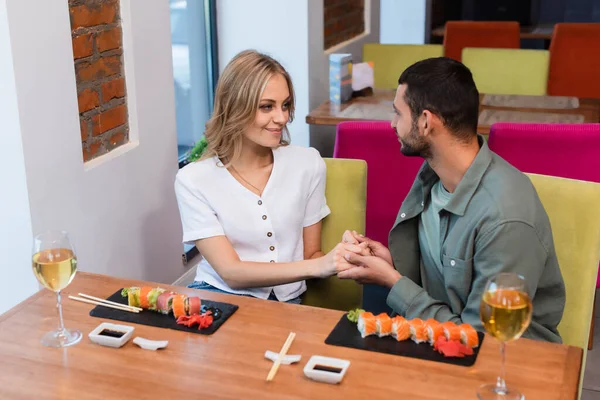 Šťastný Pár Drží Ruce Dívá Sebe Blízkosti Lahodné Sushi Restauraci — Stock fotografie