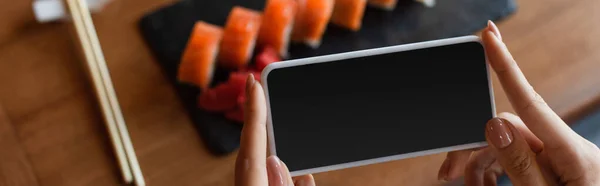 Cropped View Woman Holding Smartphone Blank Screen Blurred Sushi Rolls — Stock Photo, Image