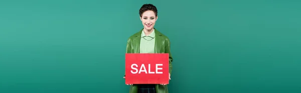 Stylish Brunette Woman Holding Placard Sale Lettering While Smiling Camera — Foto Stock