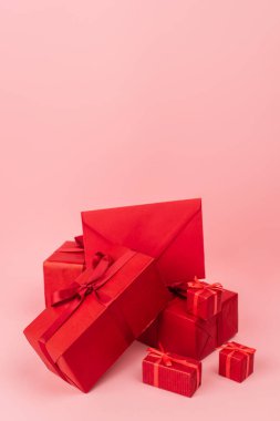 kırmızı paketlenmiş hediye kutuları, kurdeleler ve pembe zarflar. 