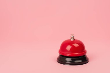Pembe üzerine izole edilmiş kırmızı ve metalik çan