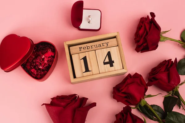 月历附近红玫瑰顶视图 有14个2月的刻字 五彩纸屑和粉色订婚戒指 — 图库照片