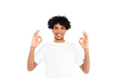 Neşeli Afro-Amerikan tişörtlü adam beyaz üzerinde izole edilmiş iyi bir jest gösteriyor.