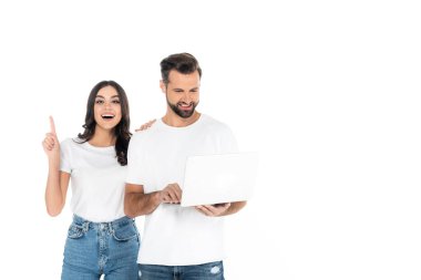 Heyecanlı kadın, dizüstü bilgisayarı olan gülümseyen bir adamı işaret ediyor.