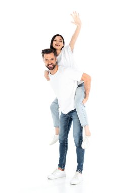 Kot pantolonlu bir adam heyecanlı Asyalı bir kadının elini beyaza sallıyor.