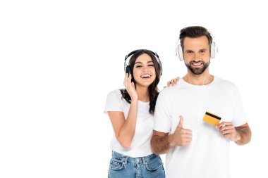 Kredi kartlı mutlu bir adam, kulaklıklı neşeli bir kadının yanında kendini göstermiş.