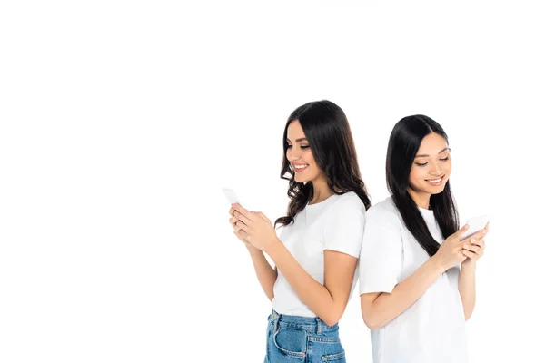 Cheerful Interracial Women Messaging Mobile Phones While Standing Back Back — Stock Photo, Image