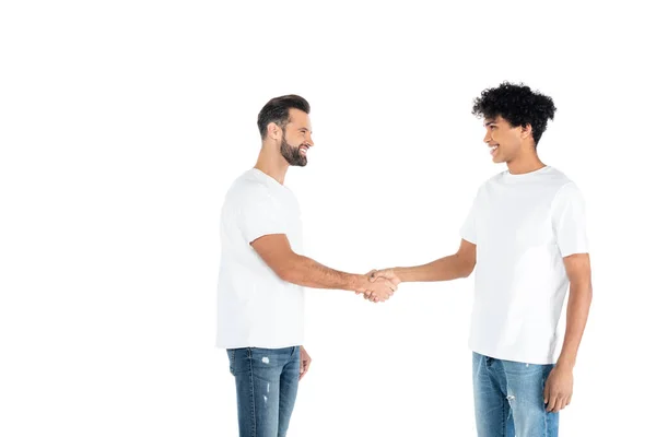 Happy Interracial Men Shirts Jeans Looking Each Other Shaking Hands — стоковое фото