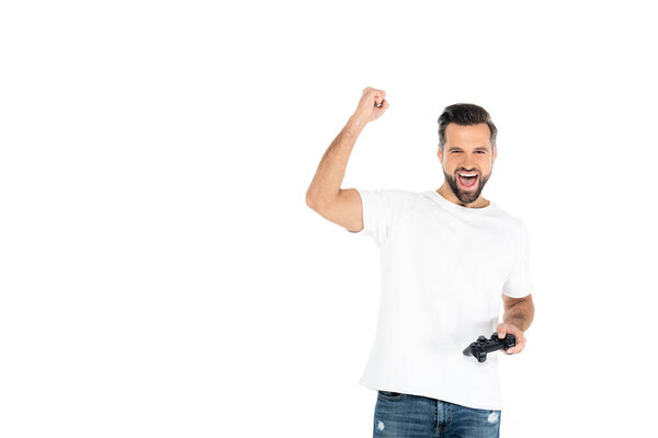 KYIV, UKRAINE - DECEMBER 5, 2021: excited man shouting and showing win gesture while playing video game isolated on white