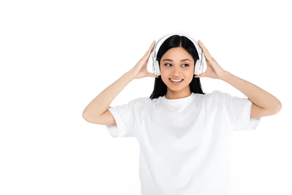 Happy Asian Woman Adjusting Headphones While Listening Music Isolated White — Stock Fotó