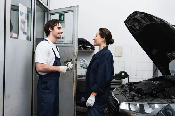 Side View Smiling Mechanic Talking Car Open Hood Garage — Stock Photo, Image