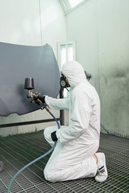Garajında hava fırçası olan işçi araba kaputunun yan görüntüsü 