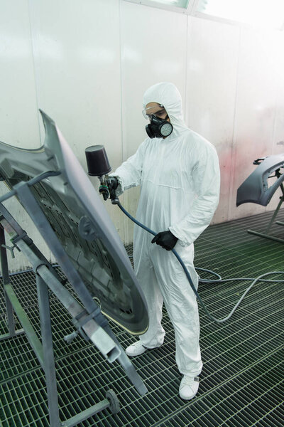 Workman coloring hood of car in service 