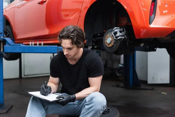 Arbetare Handskar Skriver Urklipp Nära Bilen Garage — Stockfoto