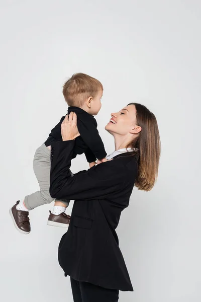 Cheerful Mother Holding Arms Toddler Son Isolated Grey — Stock fotografie