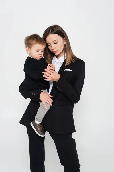 Stylish Mother Suit Holding Arms Toddler Son Isolated Grey — Stok fotoğraf