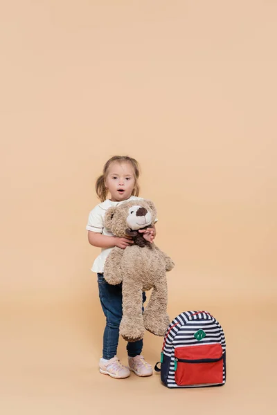Surprised Girl Syndrome Holding Soft Toy While Standing Backpack Beige — Zdjęcie stockowe