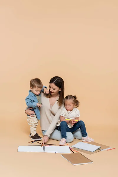 Cheerful Mother Sitting Girl Syndrome Toddler Boy Colorful Pencils Beige — Foto Stock