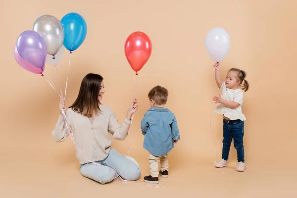 Cheerful Mother Sitting Girl Syndrome Toddler Boy Holding Colorful Balloons — Foto Stock