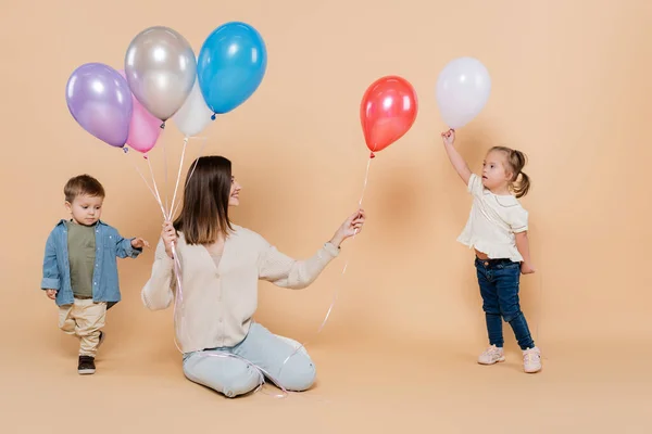 Positive Woman Sitting Girl Syndrome Toddler Boy While Holding Colorful — Stockfoto