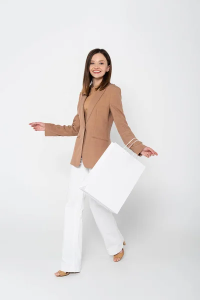 Full Length Joyful Young Woman Beige Blazer Holding Shopping Bag — 图库照片