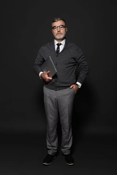 高级时尚男子手牵手站在口袋里 手提电脑在深灰色上的全景 — 图库照片