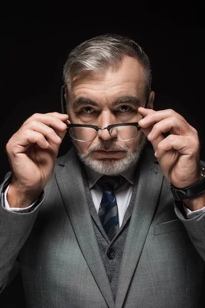 Senior Bearded Businessman Holding Eyeglasses While Looking Camera Isolated Black — Zdjęcie stockowe