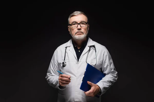 Senior Doctor Eyeglasses Holding Pencil Clipboard While Looking Camera Isolated — Foto de Stock