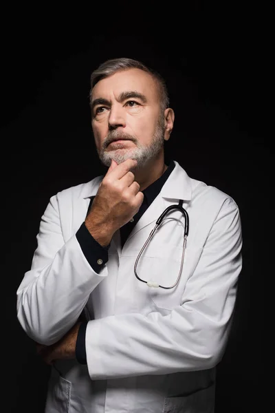 Pensive Doctor Touching Chin Looking Away While Thinking Isolated Black — Stok Foto