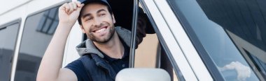 Positive courier holding cap while driving auto, banner 