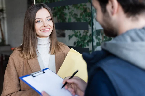 Smiling Woman Parcel Looking Blurred Courier Writing Clipboard Hallway —  Fotos de Stock