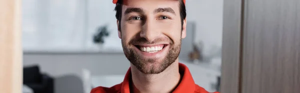 Positive Delivery Man Looking Camera Hallway Banner — Fotografia de Stock