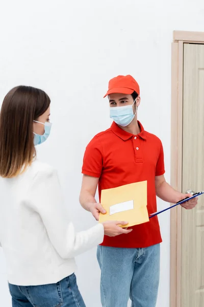 Courier Medical Mask Holding Parcel Clipboard Customer Hallway — Stok Foto