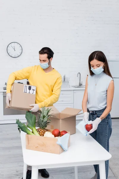 Woman Medical Mask Cleaning Apple Fruits Boyfriend Holding Carton Box — Stock Photo, Image