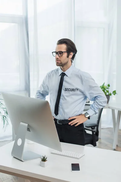 Serio Uomo Sicurezza Piedi Con Mani Sui Fianchi Vicino Monitor — Foto Stock