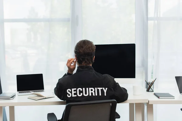 Pohled Zezadu Bezpečnostní Muž Černé Uniformě Sluchátka Sedí Blízkosti Počítačů — Stock fotografie