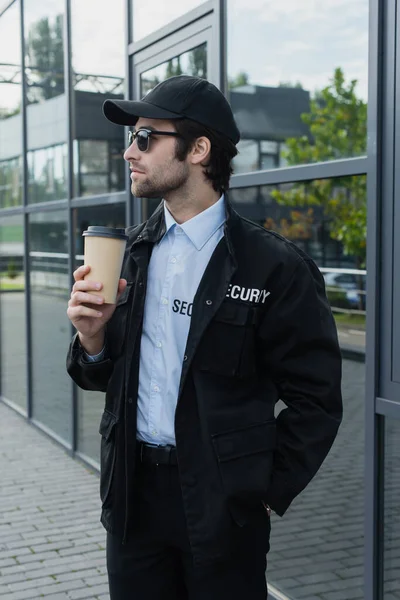 Joven Hombre Seguridad Uniforme Negro Gorra Pie Con Café Calle — Foto de Stock