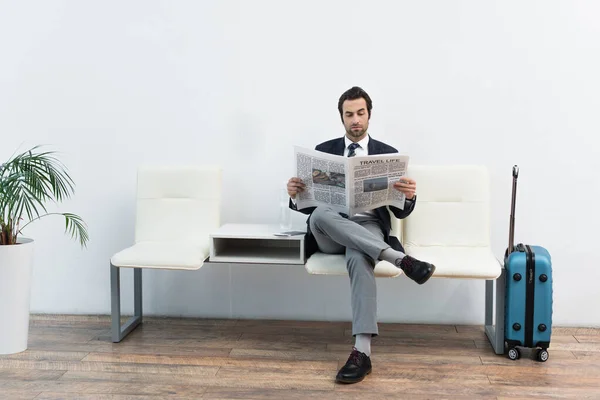 Hombre Leyendo Periódico Sala Salida Cerca Maleta — Foto de Stock