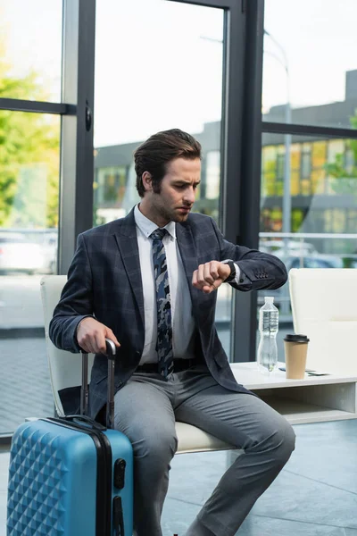 Hombre Preocupado Mirando Reloj Pulsera Mientras Está Sentado Sala Salida —  Fotos de Stock