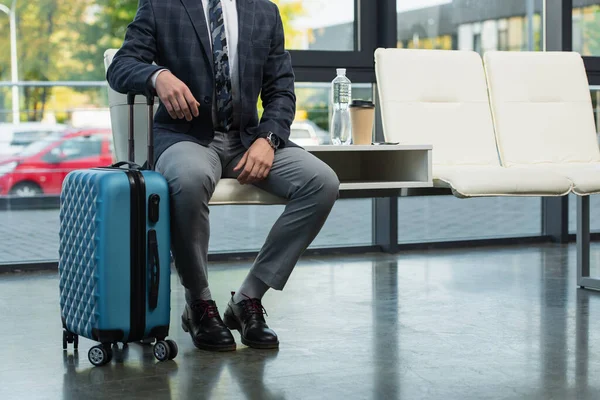Cropped View Traveler Sitting Departure Lounge Suitcase Bottle Water Paper — Stock Photo, Image
