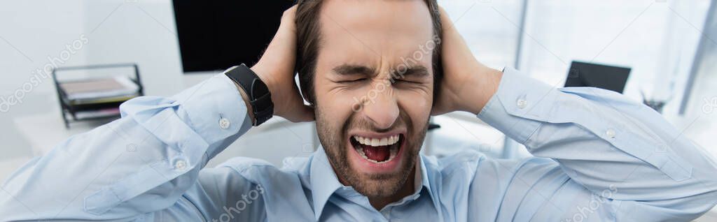 angry security man with closed eyes touching head while screaming in office, banner