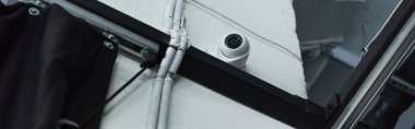 low angle view of supervision camera on white wall near metal construction, banner clipart