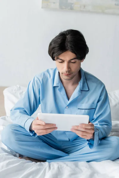 Brunette Man Digital Tablet Sitting Crossed Legs White Bedding — Stock Photo, Image