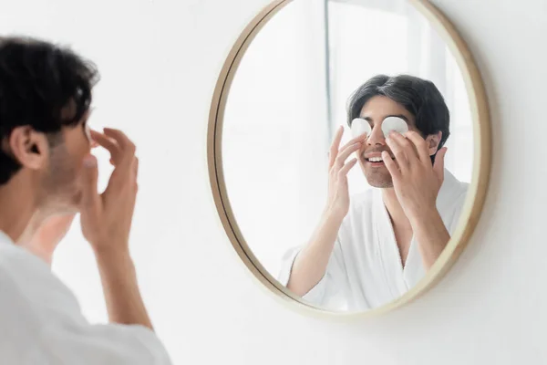 Sorrindo Homem Roupão Banho Branco Limpando Olhos Perto Espelho Banheiro — Fotografia de Stock