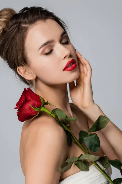 Encantadora Mujer Con Rosa Roja Tocando Cara Mientras Posa Con —  Fotos de Stock