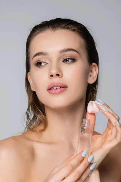 Encantadora Mujer Con Botella Aceite Cosmético Mirando Hacia Otro Lado — Foto de Stock