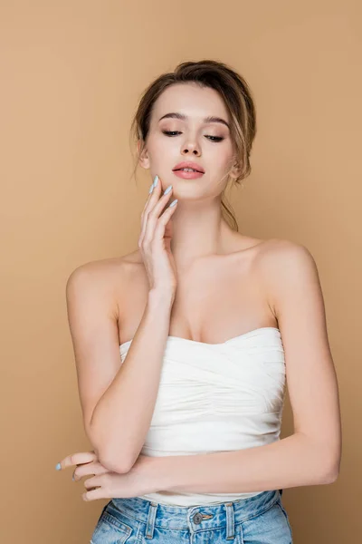 Jonge Charmante Vrouw Strapless Top Aanraken Gezicht Geïsoleerd Beige — Stockfoto