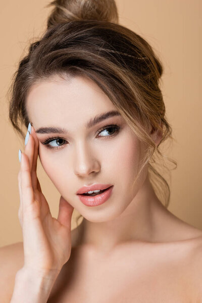 close up view of pretty woman with perfect skin and natural makeup isolated on beige