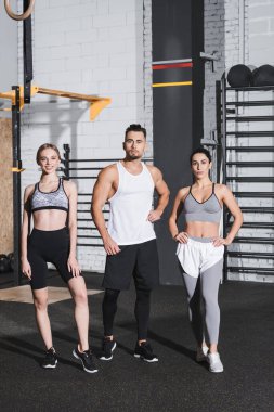 Spor giyim sektöründeki ırklar arası insanlar spor merkezindeki kameralara bakıyor. 