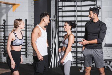 Spor kıyafetlerinde spor salonunda pozitif ırklar arası arkadaşlar konuşuyor. 